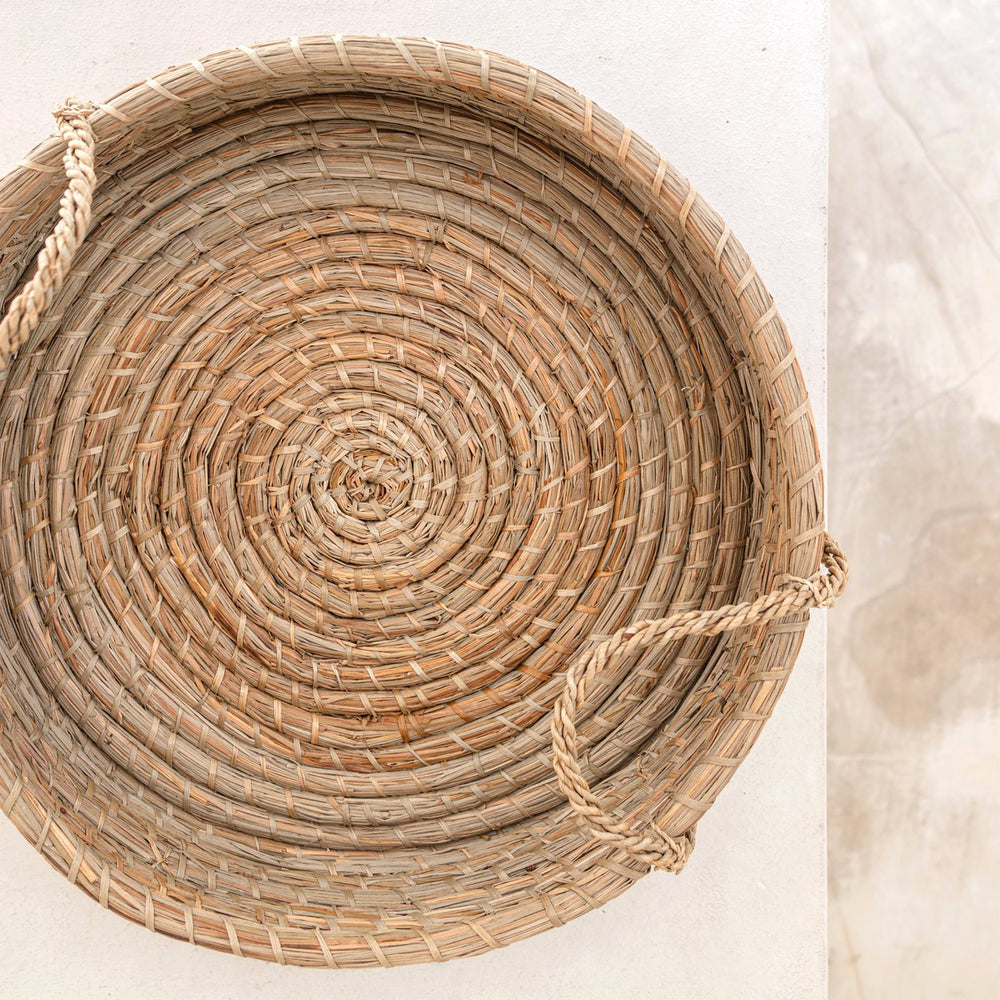 Beige woven seagrass round serving tray with handles