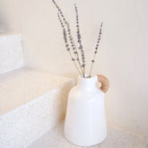 White clay vase with rattan-wrapped handle