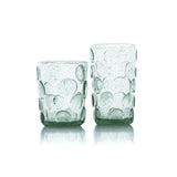 Two green glass tumblers with bubble design on a white background