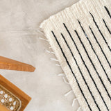 White handwoven cotton rug with black stripes
