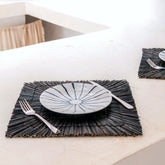 Black seagrass placemat with radial woven pattern
