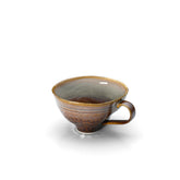 Ceramic cup with brown and gray glaze on a white background