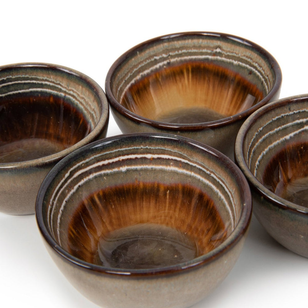 Set of four ceramic bowls with brown and beige glaze on a white background