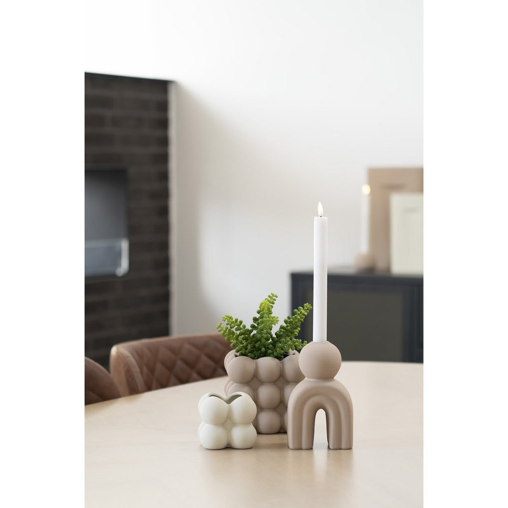 Decorative items on a table including a candle, plant, and ceramic pieces.