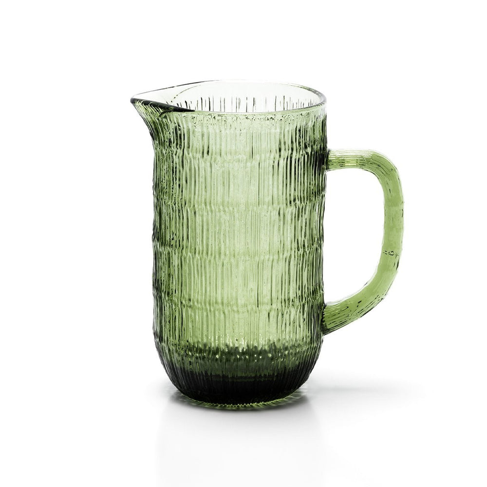 Green glass pitcher with ribbed texture on a white background