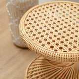 Beige rattan round side table with hourglass-shaped struts