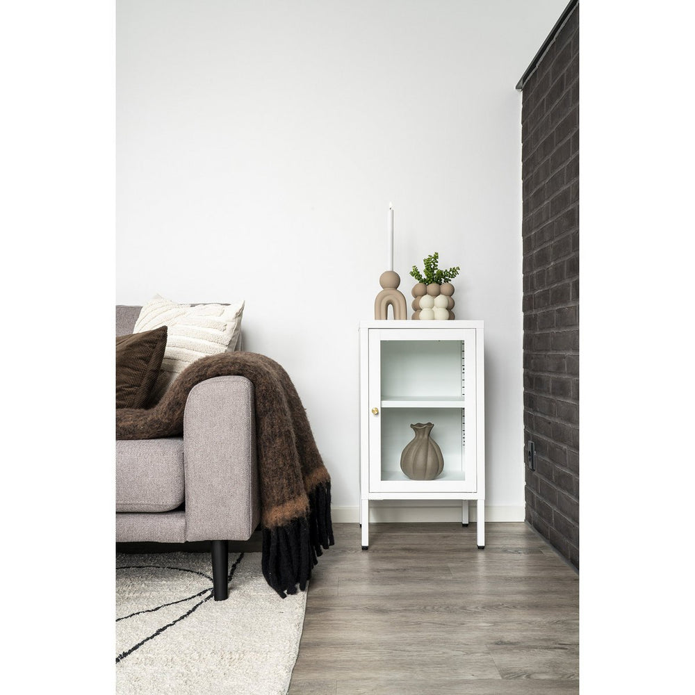 Living room with a gray sofa, white cabinet, and decorative items.
