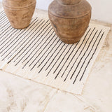 White handwoven cotton rug with black stripes